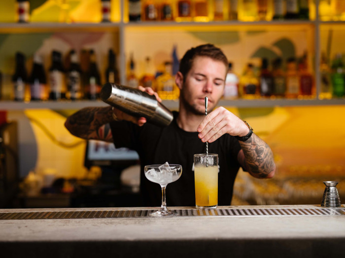 cocktail bartender mixing a drink in a bar